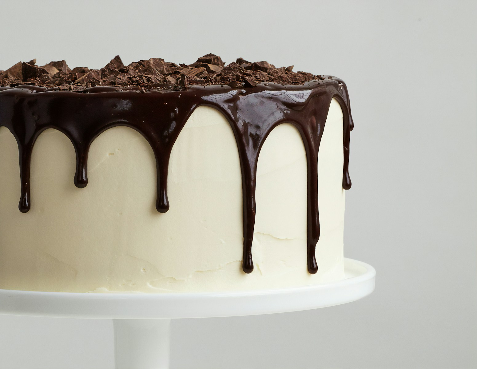 white cake with chocolate syrup on white ceramic plate